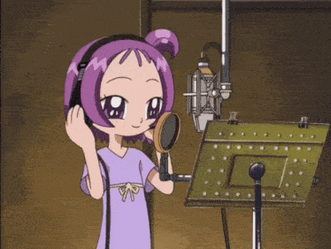 a girl with purple hair is standing in front of a microphone with headphones on