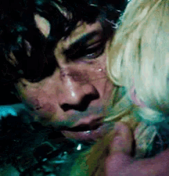 a close up of a man 's face with a woman 's face behind him .