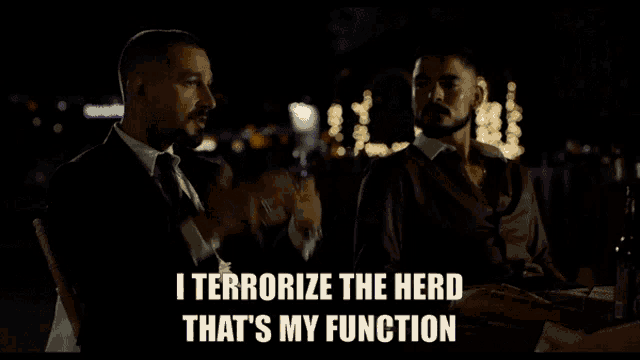 a man is pointing a gun at another man with the words i terrorize the herd that 's my function below him