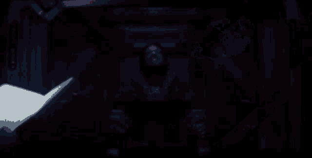 a close up of a person 's hand holding a remote control in a dark room .