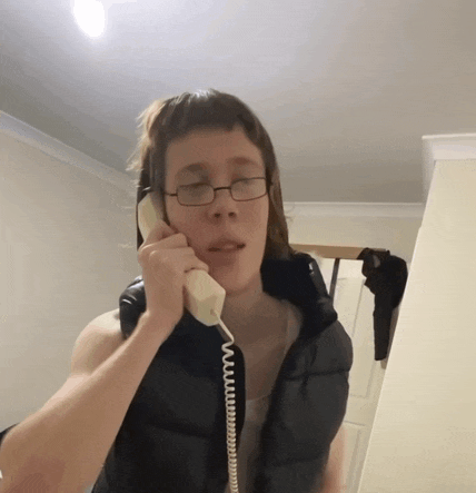 a man wearing glasses talks on a telephone