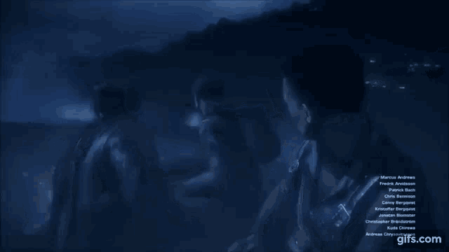 a group of people standing in a dark room with a gifs.com logo on the bottom right