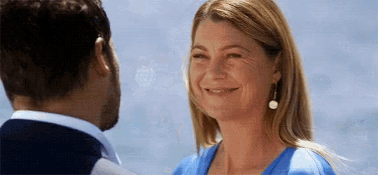 a man and a woman are looking into each other 's eyes and smiling .