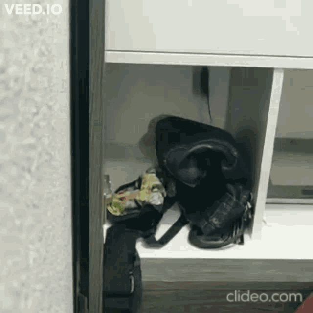 a black bag is sitting on a shelf in a closet