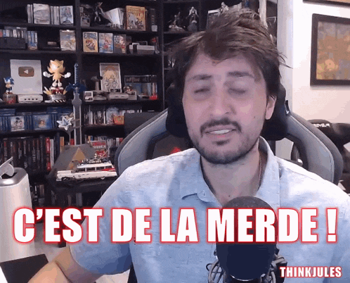 a man is sitting in front of a microphone with the words " c'est de la merde " written above him