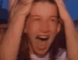 a blurry picture of a woman wearing a striped shirt with her hands on her head