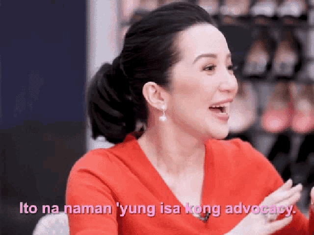 a woman in a red sweater is talking about advocacy