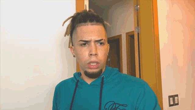 a man with dreadlocks and a tattoo on his forehead