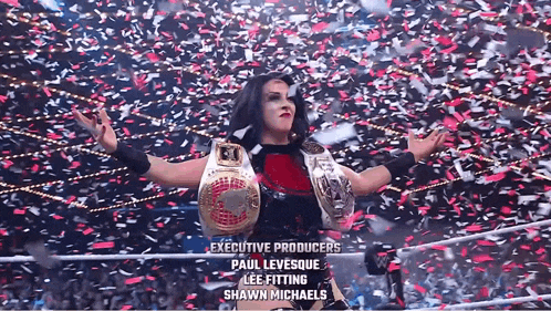 a woman in a wrestling ring with executive producers paul levesque lee fitting and shawn michaels written on the bottom