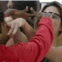 a woman in a red shirt is taking a selfie with a man .