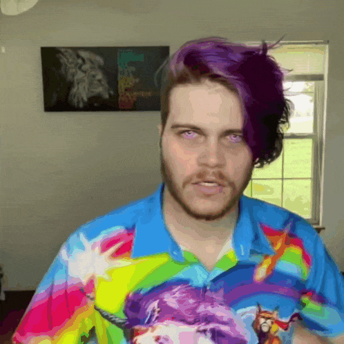 a man with purple hair wearing a colorful shirt