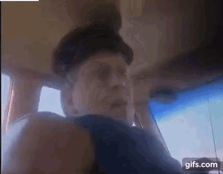 a man is sitting in the back seat of a car with the words `` ertu ad kalla mig fifl '' written above him .