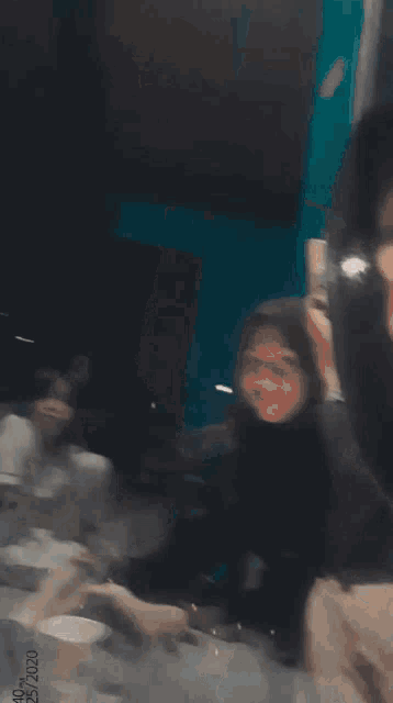 a girl wearing a hijab is taking a picture of herself in front of a mirror .