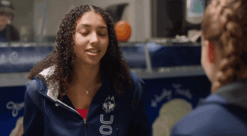 a girl wearing a blue jacket that says oc on the back