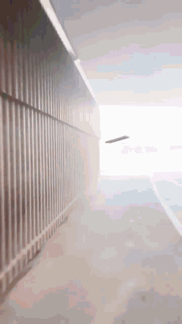 a plane is flying through a tunnel with a fence along the side
