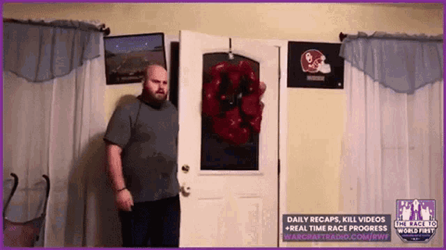 a man is standing in front of a door with a wreath on it