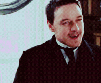 a man in a suit and tie is smiling and looking at the camera
