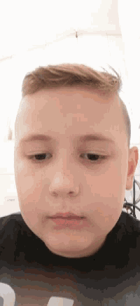 a close up of a child 's face with a black shirt with the number 3 on it