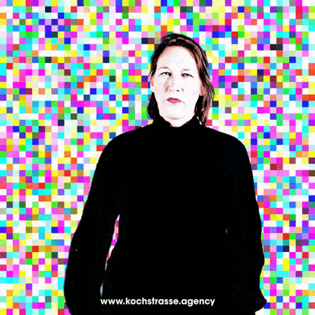 a woman stands in front of a colorful pixelated background with the website www.kochstrasse.agency