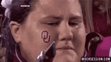 a woman with a r on her forehead is crying .