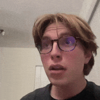 a man wearing glasses is making a funny face