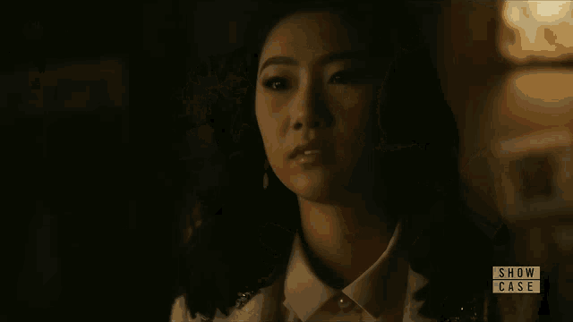 a woman in a dark room with the words show case on the bottom right