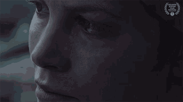 a close up of a woman 's face with a laurel wreath on the bottom