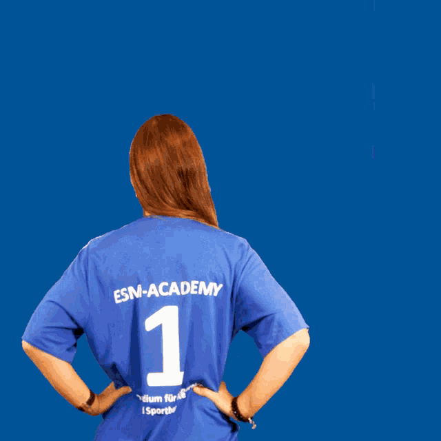 a woman wearing a blue gsm academy shirt smiles for the camera