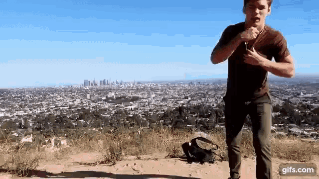 a man is running on a hill overlooking a city