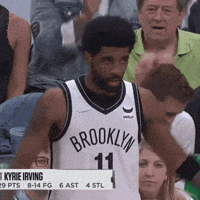 a man in a brooklyn jersey stands in front of a crowd of people