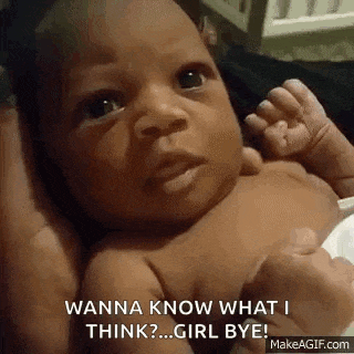 a baby is being held by a person and looking at the camera .