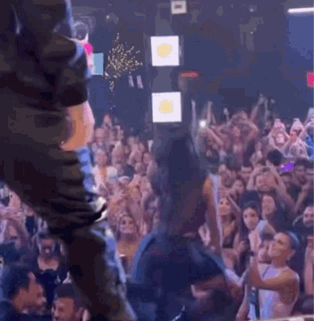 a woman is dancing in front of a crowd of people .