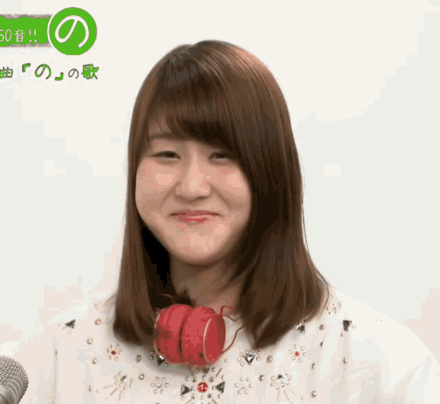 a woman wearing red headphones looks at the camera