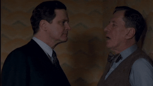 two men in suits and bow ties are standing next to each other