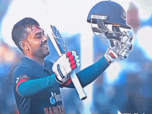 a cricket player is holding a bat and helmet in his hands .