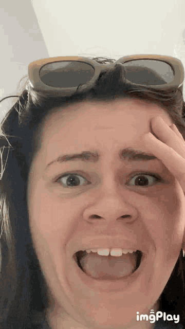 a woman wearing sunglasses is making a funny face with her tongue hanging out