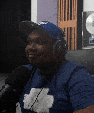a man wearing headphones and a blue shirt is smiling
