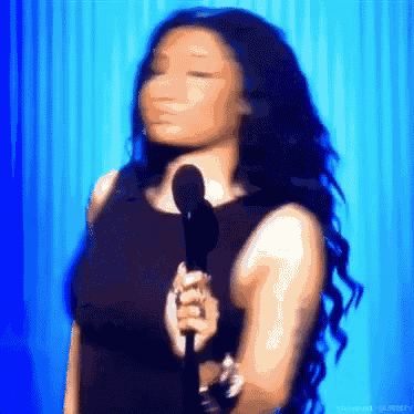 a woman in a black dress is singing into a microphone
