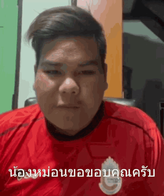 a man wearing a red shirt has a foreign language written on his face
