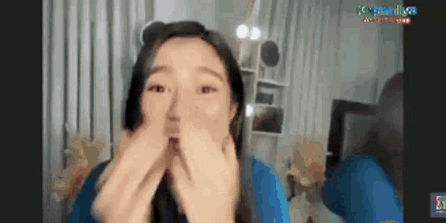 a woman is making a funny face in front of a screen that says ' k-popnica ' on it