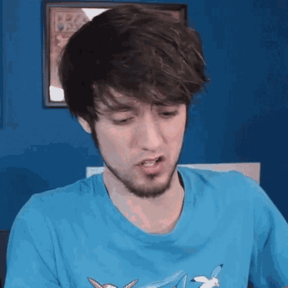 a man with a beard is wearing a blue t-shirt with a bird on it .