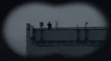 a black and white photo of a body of water with a bridge in the distance .