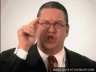 a man in a suit and tie is pointing at the camera .