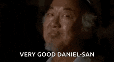 a close up of a man 's face with the words `` very good daniel-san '' written on it .