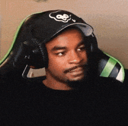 a man wearing a black hat and headphones is sitting in a chair .