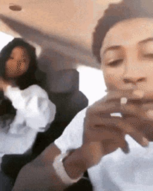 a man and a woman are sitting in a car looking at their cell phones
