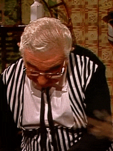 a man wearing glasses and a striped shirt with a tie