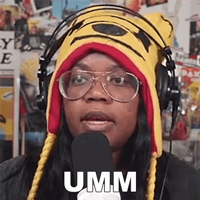 a woman wearing a winnie the pooh hat and headphones says umm in front of a microphone