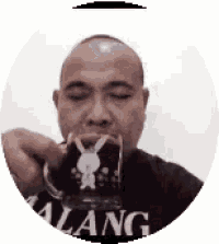 a bald man is drinking from a mug with a rabbit on it .