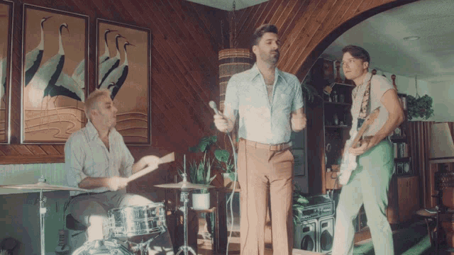 a man singing into a microphone while playing drums